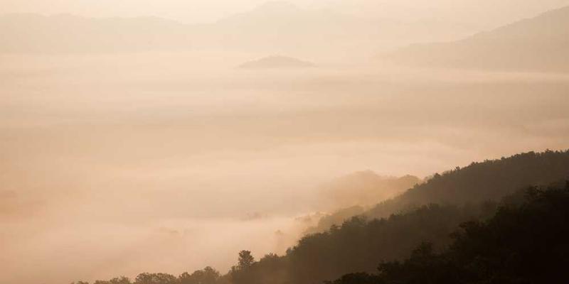 一位老人在庙宇前虔诚地祈祷，神态庄重。说明：老人对庙宇的敬仰，体现了家乡文化的传承。