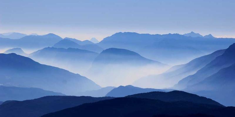 一座古老的庙宇，周围是郁郁葱葱的树木，阳光透过树叶洒在古老的石阶上，显得格外宁静。说明：古老的庙宇，见证着家乡的历史变迁。