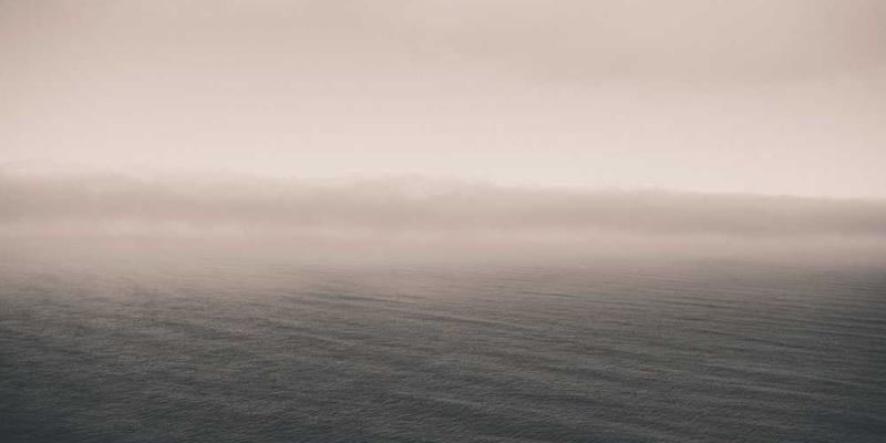 忧郁的街景，天空灰暗，街道冷清，一个人独自走过，背影显得孤独而沉重