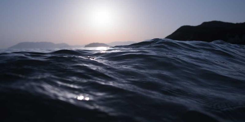 一位男子紧闭双眼，泪水在眼眶中打转，周围环境显得模糊不清。说明：长时间不眨眼导致的视觉模糊与情感冲击。