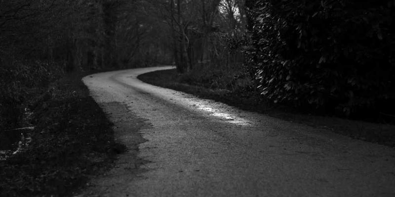 一位年轻人在家中整理旧衣，眼中闪烁着怀念的光芒